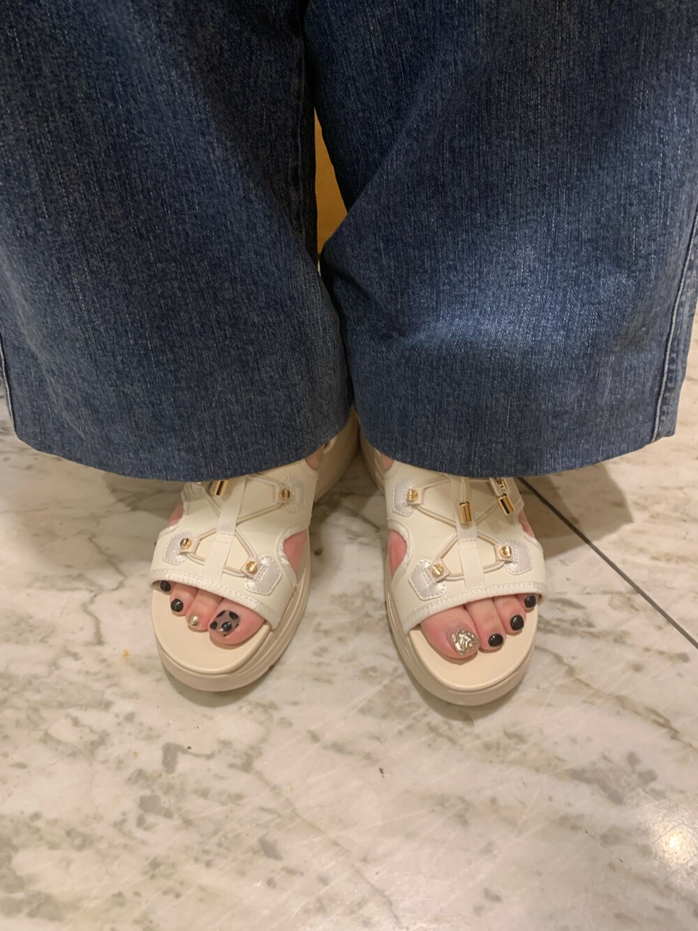 ホワイト系のサンダルを着用したレディースの春コーディネートの2枚目の写真