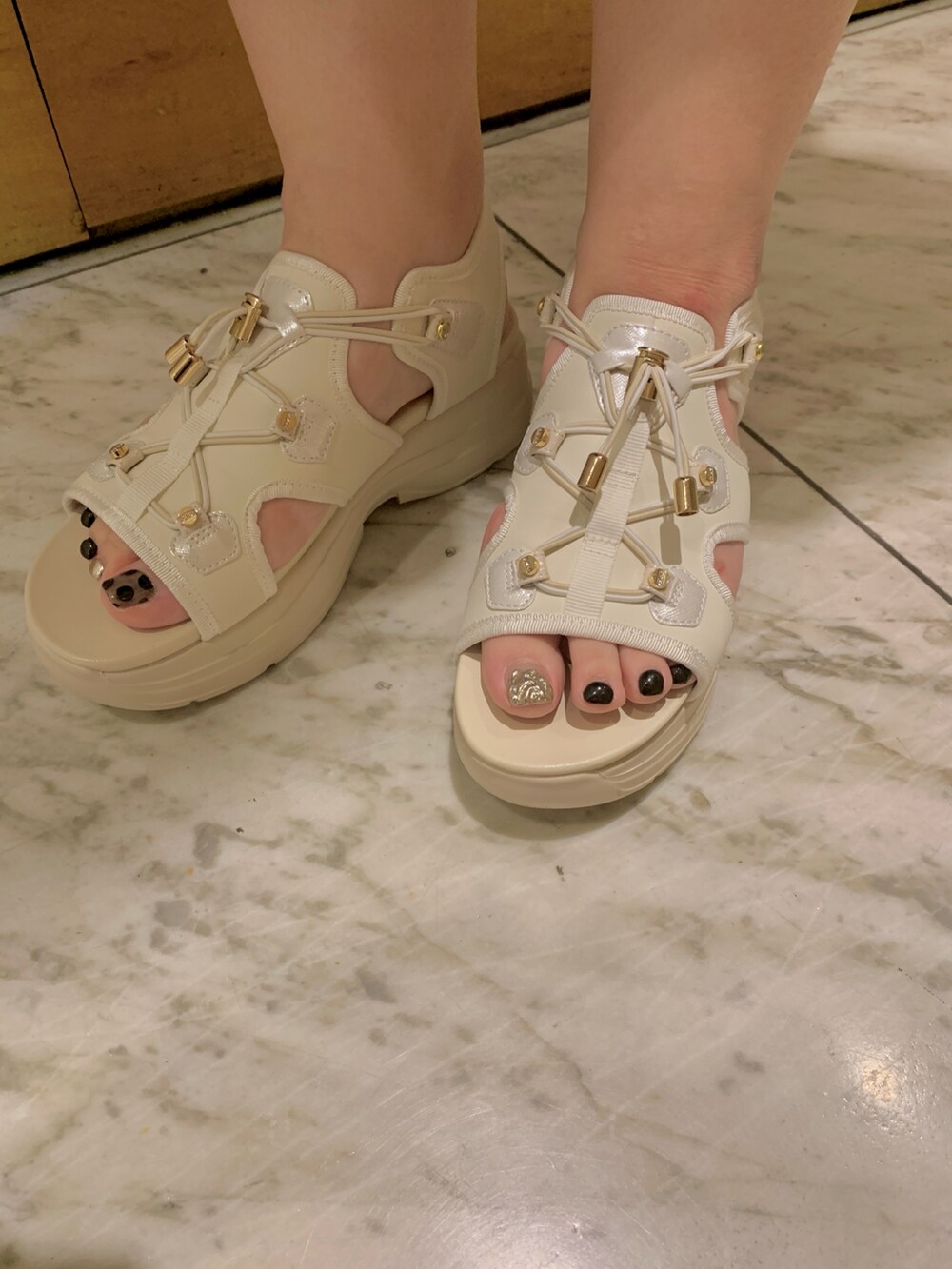 ホワイト系のサンダルを着用したレディースの春コーディネートの3枚目の写真