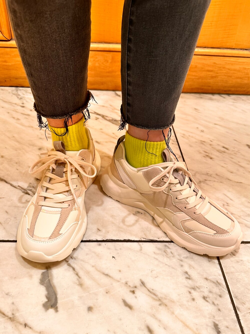 ホワイト系のスニーカーを着用したレディースの春コーディネートの2枚目の写真