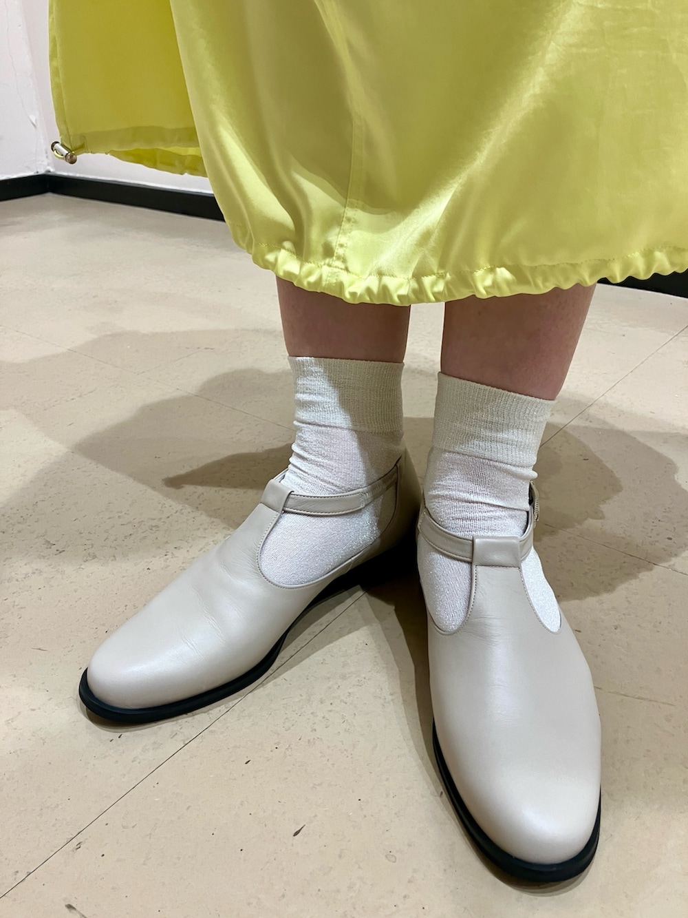 ホワイト系のパンプスを着用したレディースの春コーディネートの2枚目の写真