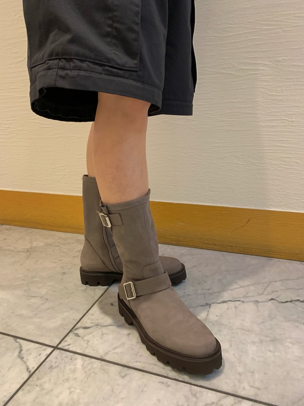 グレー系のブーツを着用したレディースの秋コーディネートの2枚目の写真