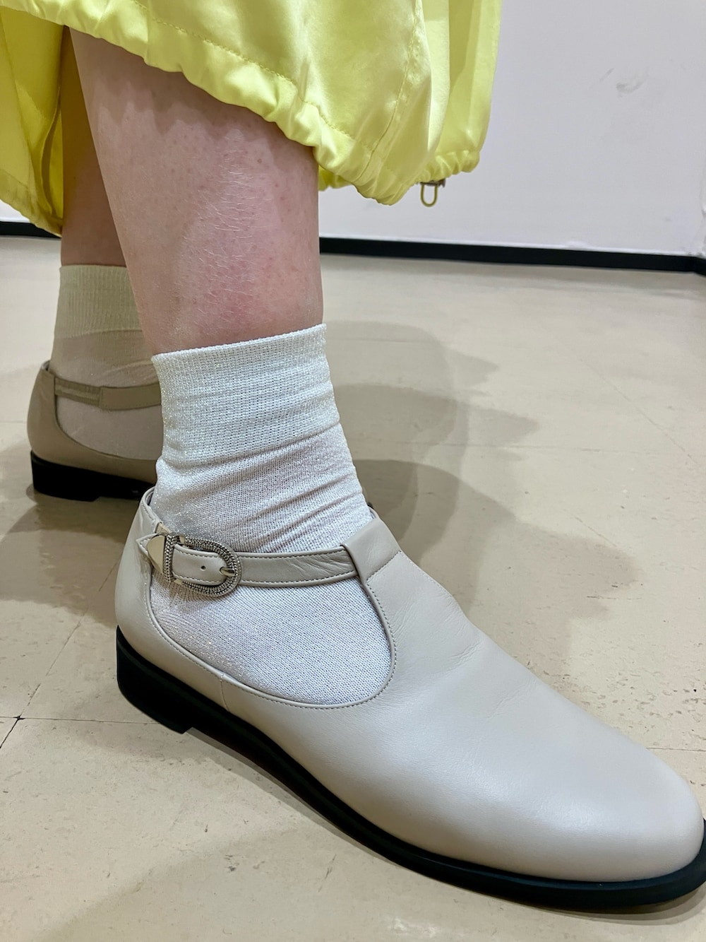 ホワイト系のパンプスを着用したレディースの春コーディネートの3枚目の写真
