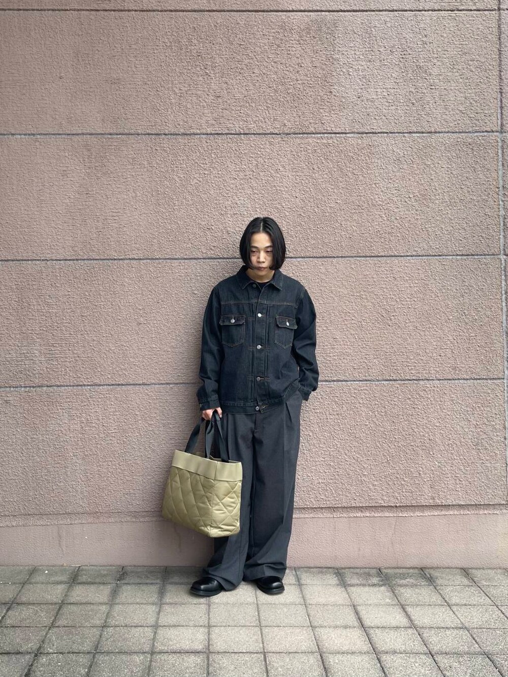 グリーン系のトートバッグ、グレー系のその他パンツ、ブラック系のデニムジャケットを着用したメンズの冬コーディネートの2枚目の写真