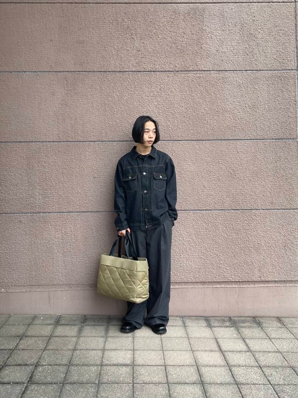 グリーン系のトートバッグ、グレー系のその他パンツ、ブラック系のデニムジャケットを着用したメンズの冬コーディネートの3枚目の写真