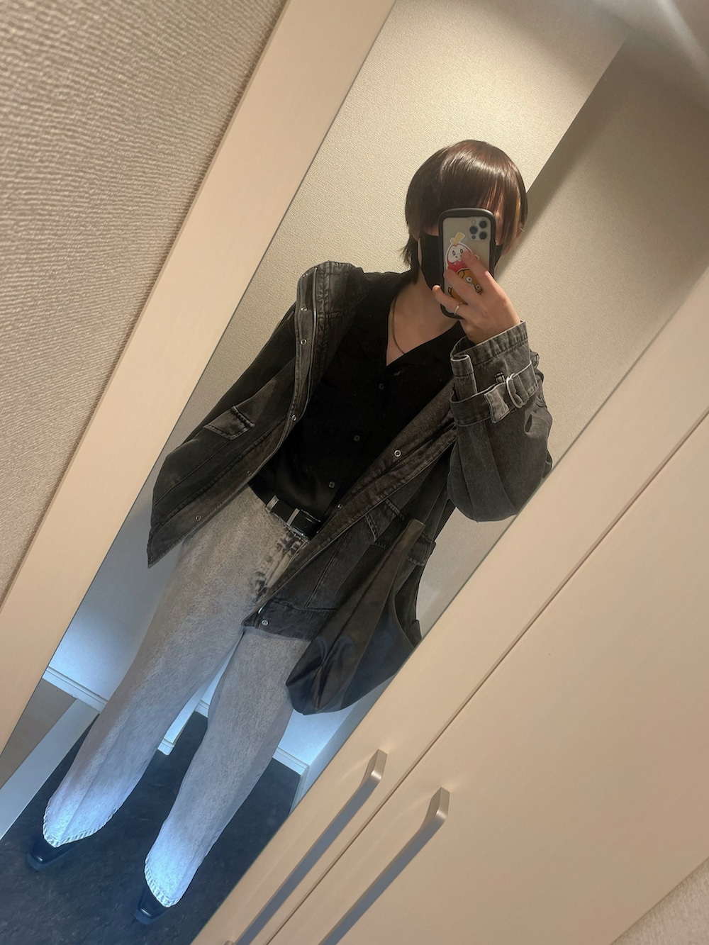 ブラック系のマウンテンパーカー、ブラック系のシャツ/ブラウス、ホワイト系のデニムパンツを着用したメンズの秋コーディネートの2枚目の写真