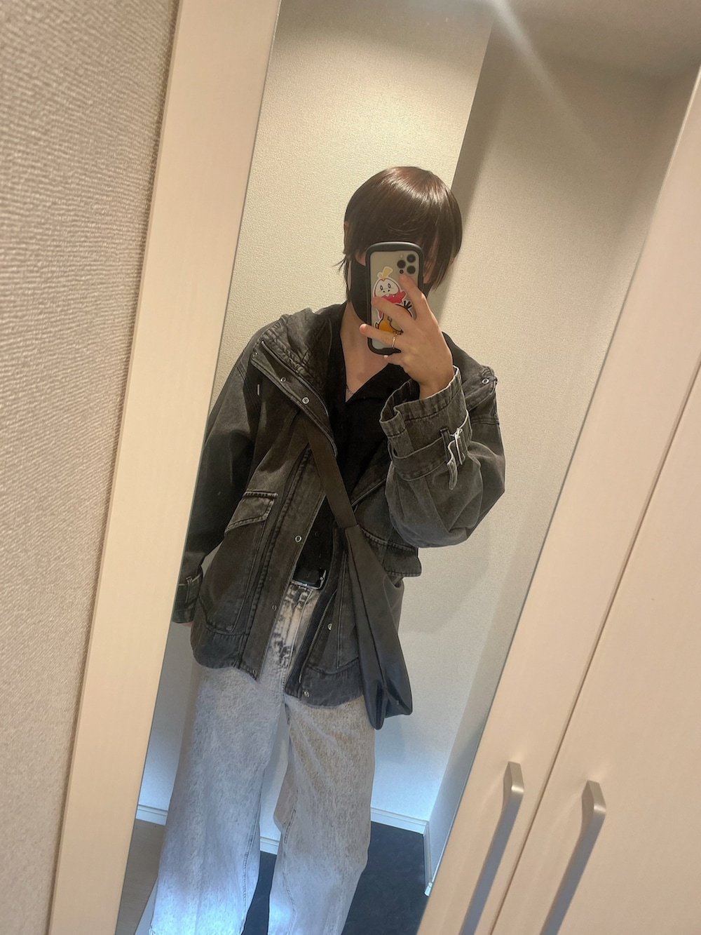 ブラック系のマウンテンパーカー、ブラック系のシャツ/ブラウス、ホワイト系のデニムパンツを着用したメンズの秋コーディネートの3枚目の写真