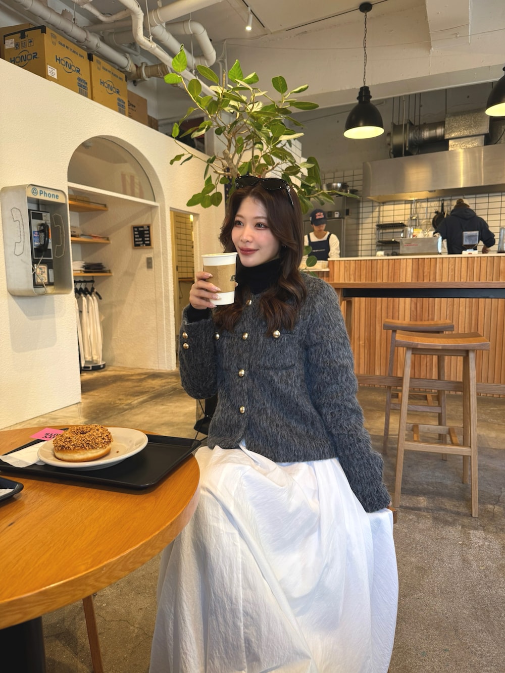 ホワイト系のスカート、グレー系のジャケット/アウター、ブラック系のブーツを着用したレディースの冬コーディネートの2枚目の写真