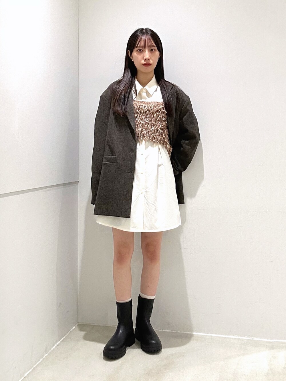 ホワイト系のシャツ/ブラウス、ブラック系のブーツ、イエロー系のニット/セーターを着用したレディースの秋コーディネートの3枚目の写真