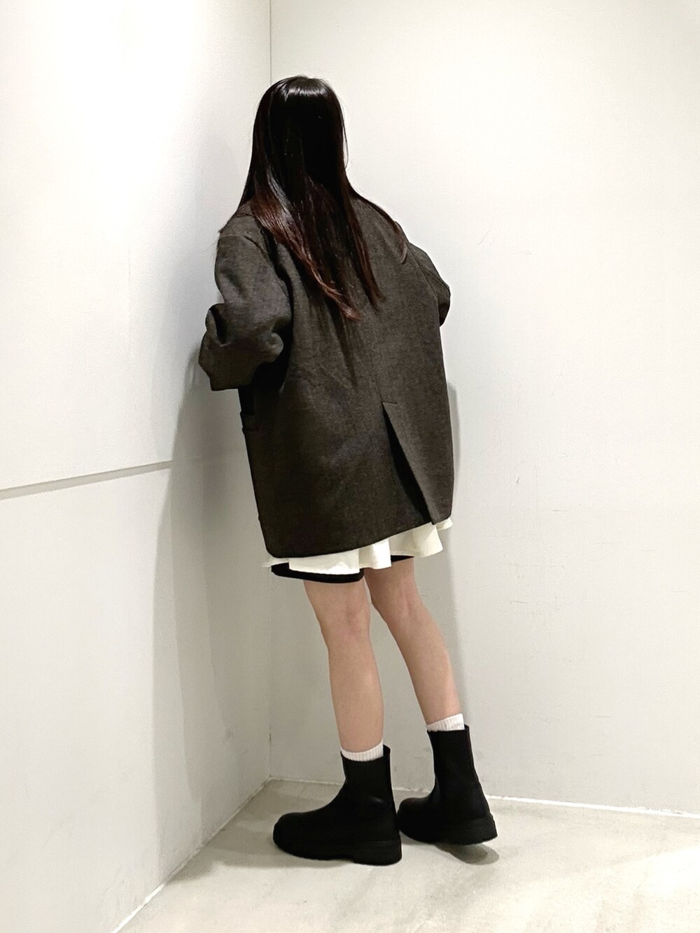 ホワイト系のシャツ/ブラウス、ブラック系のブーツ、イエロー系のニット/セーターを着用したレディースの秋コーディネートの5枚目の写真