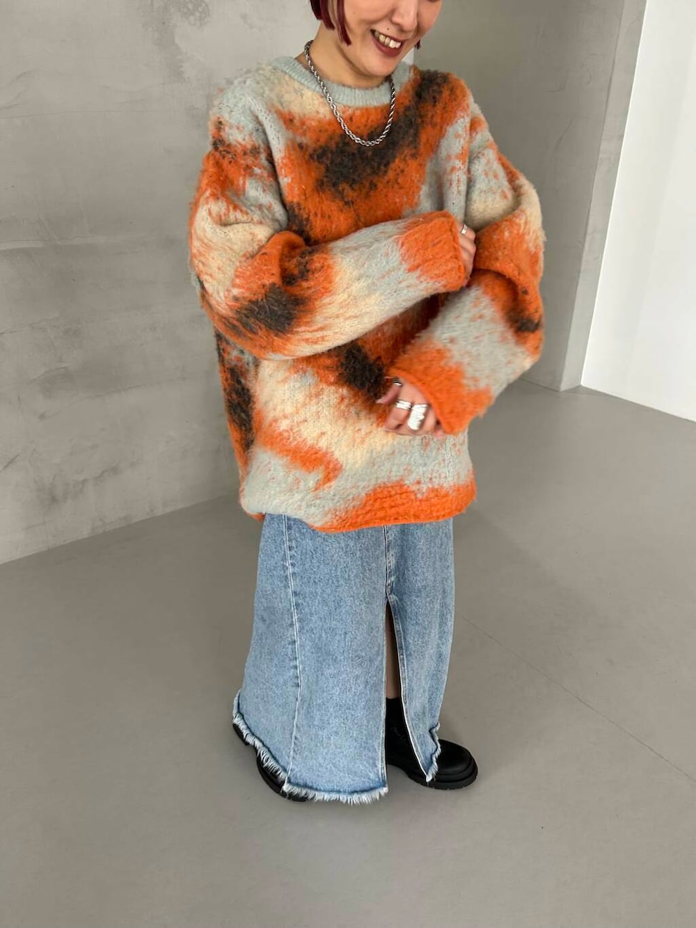 ブラック系のブーツ、オレンジ系のニット/セーター、グレー系のニットキャップ/ビーニーを着用したレディースの秋コーディネートの3枚目の写真