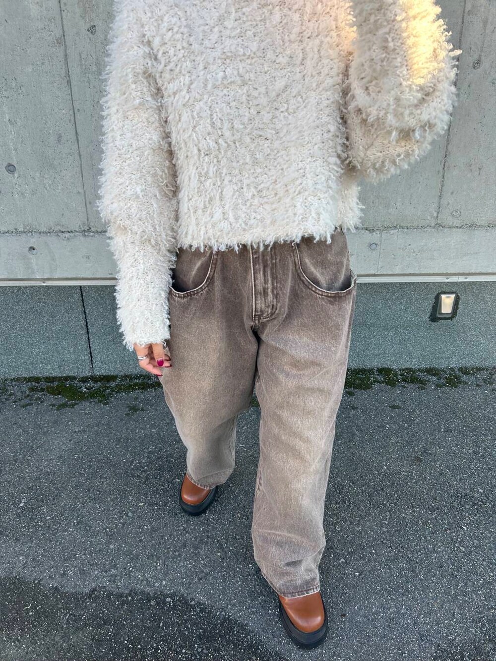 ホワイト系のニット/セーター、ブラウン系のデニムパンツを着用したレディースの秋コーディネートの6枚目の写真