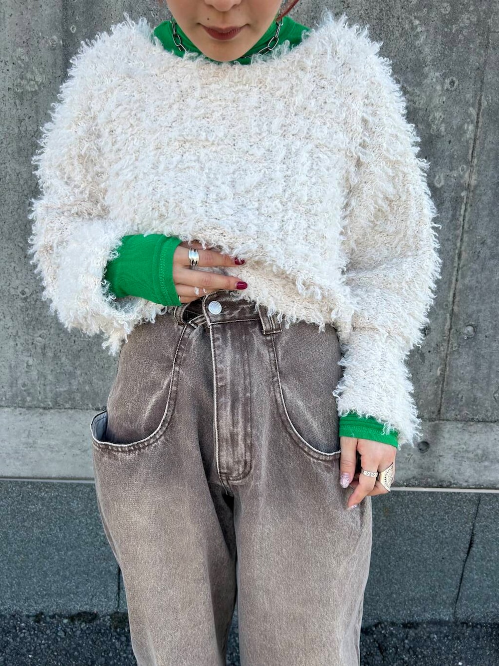 ホワイト系のニット/セーター、ブラウン系のデニムパンツを着用したレディースの秋コーディネートの4枚目の写真