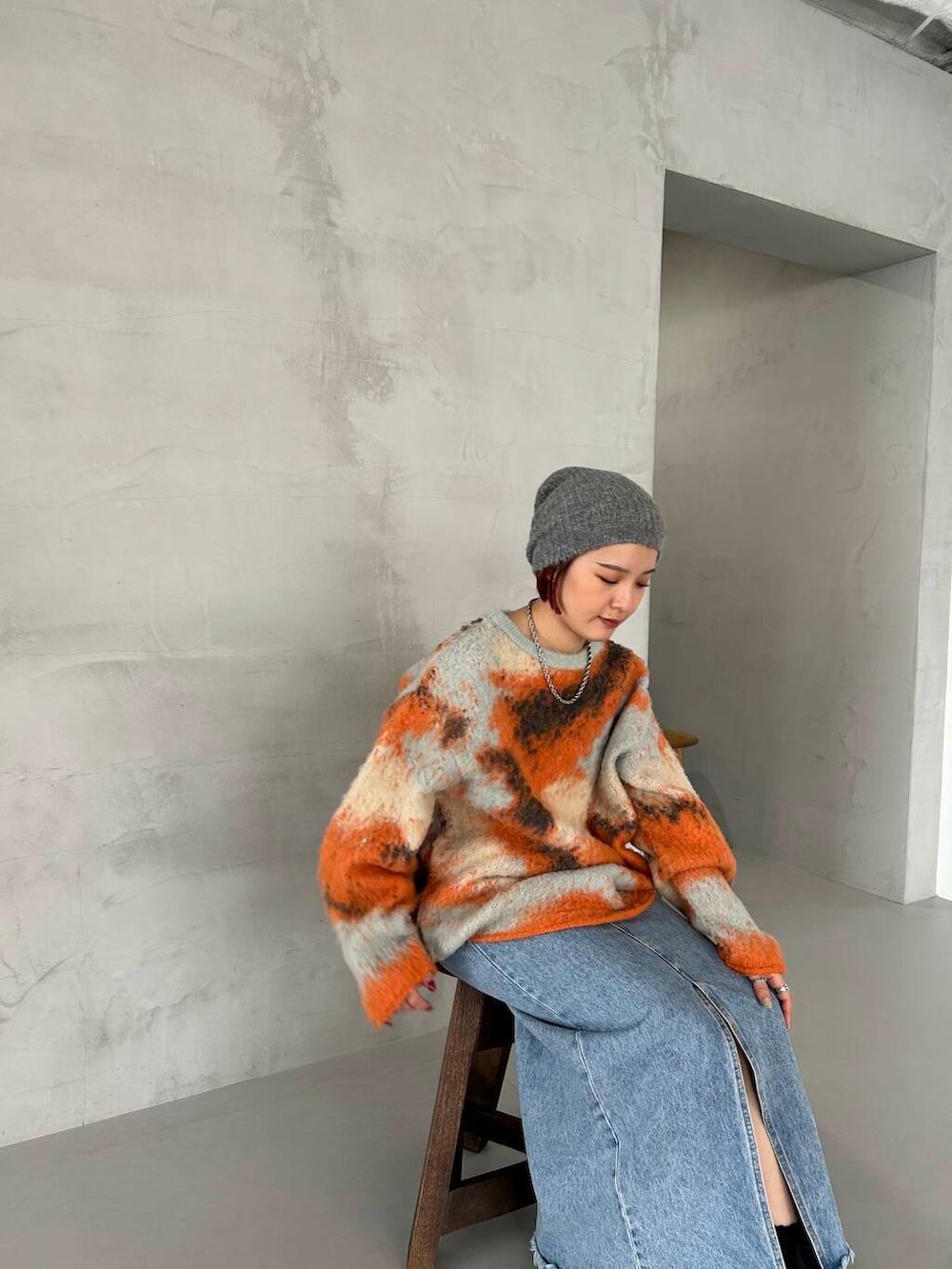 ブラック系のブーツ、オレンジ系のニット/セーター、グレー系のニットキャップ/ビーニーを着用したレディースの秋コーディネートの4枚目の写真