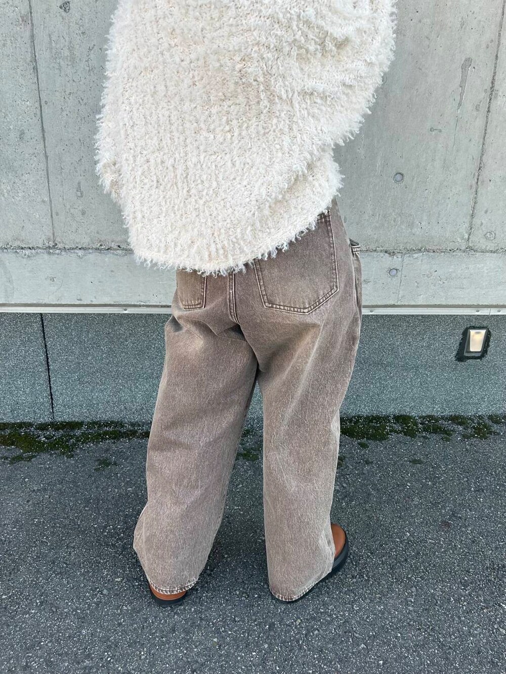 ホワイト系のニット/セーター、ブラウン系のデニムパンツを着用したレディースの秋コーディネートの5枚目の写真