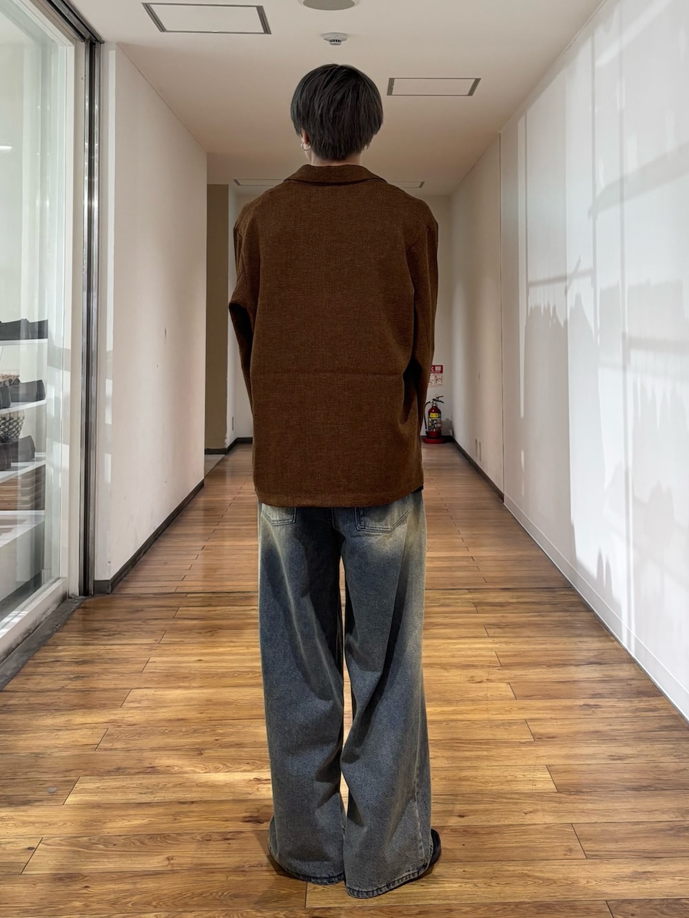 ブラウン系のその他アウター、ブラック系のタンクトップ、ブルー系のデニムパンツを着用したメンズの秋コーディネートの5枚目の写真