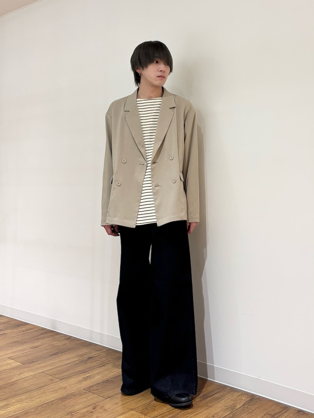 ベージュ系のテーラードジャケット、ホワイト系のTシャツ/カットソー、ブルー系のデニムパンツを着用したメンズの春コーディネートの2枚目の写真