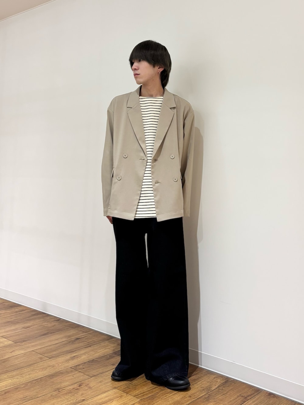 ベージュ系のテーラードジャケット、ホワイト系のTシャツ/カットソー、ブルー系のデニムパンツを着用したメンズの春コーディネートの6枚目の写真