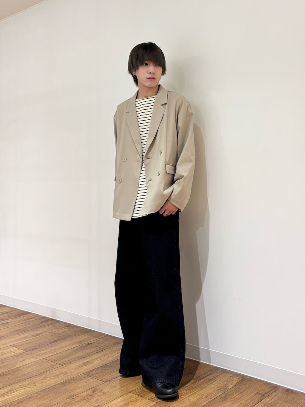 ベージュ系のテーラードジャケット、ホワイト系のTシャツ/カットソー、ブルー系のデニムパンツを着用したメンズの春コーディネートの5枚目の写真