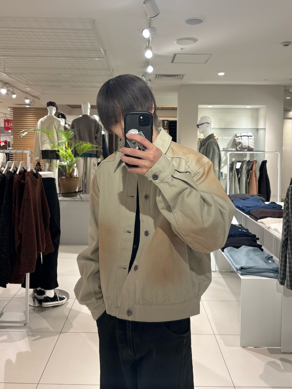 グリーン系のデニムジャケット、ブラック系のニット/セーター、ブラック系のデニムパンツを着用したメンズの冬コーディネートの5枚目の写真