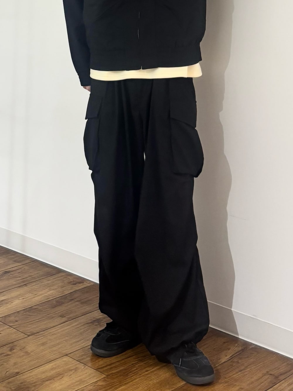 ブラック系のブルゾン、イエロー系のTシャツ/カットソー、ブラック系のカーゴパンツを着用したメンズの春コーディネートの8枚目の写真