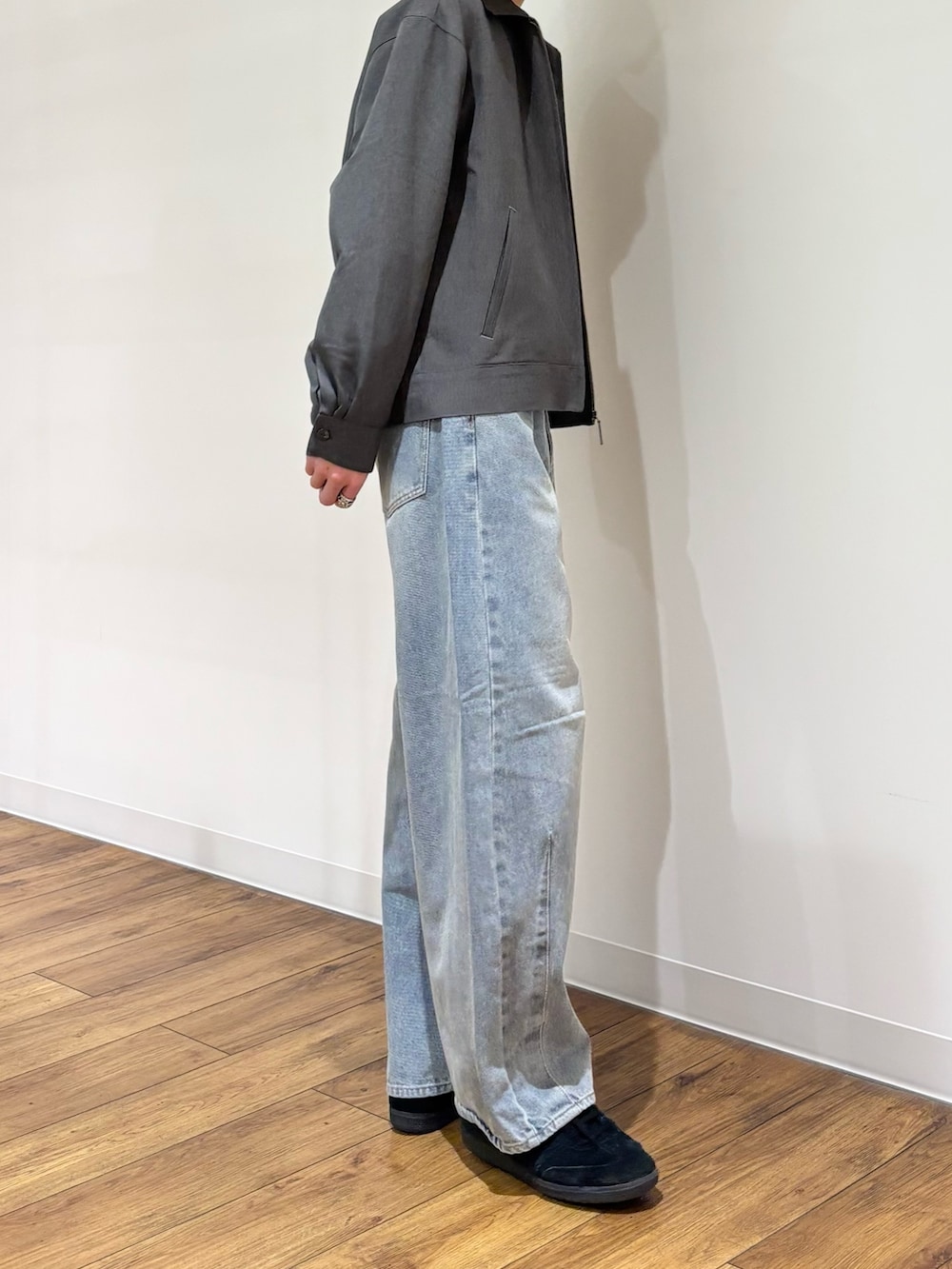 グレー系のブルゾン、グレー系のTシャツ/カットソー、ブルー系のデニムパンツを着用したメンズの冬コーディネートの4枚目の写真