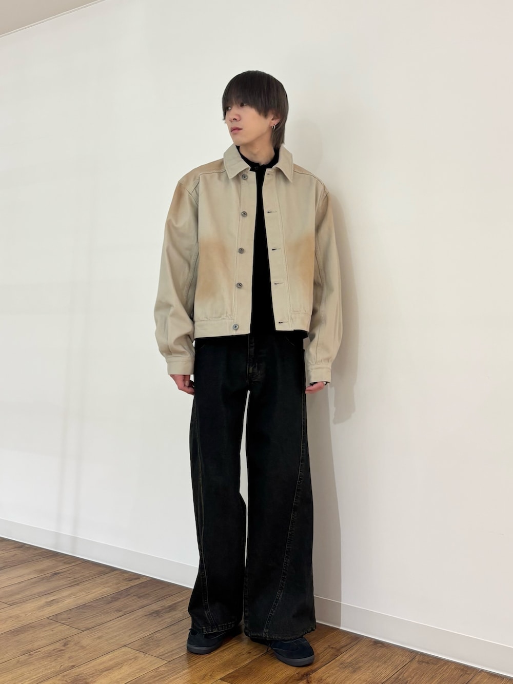 グリーン系のデニムジャケット、ブラック系のニット/セーター、ブラック系のデニムパンツを着用したメンズの冬コーディネートの3枚目の写真