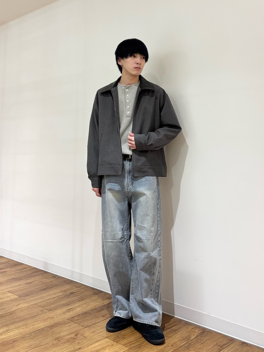 グレー系のブルゾン、グレー系のTシャツ/カットソー、ブルー系のデニムパンツを着用したメンズの冬コーディネートの2枚目の写真