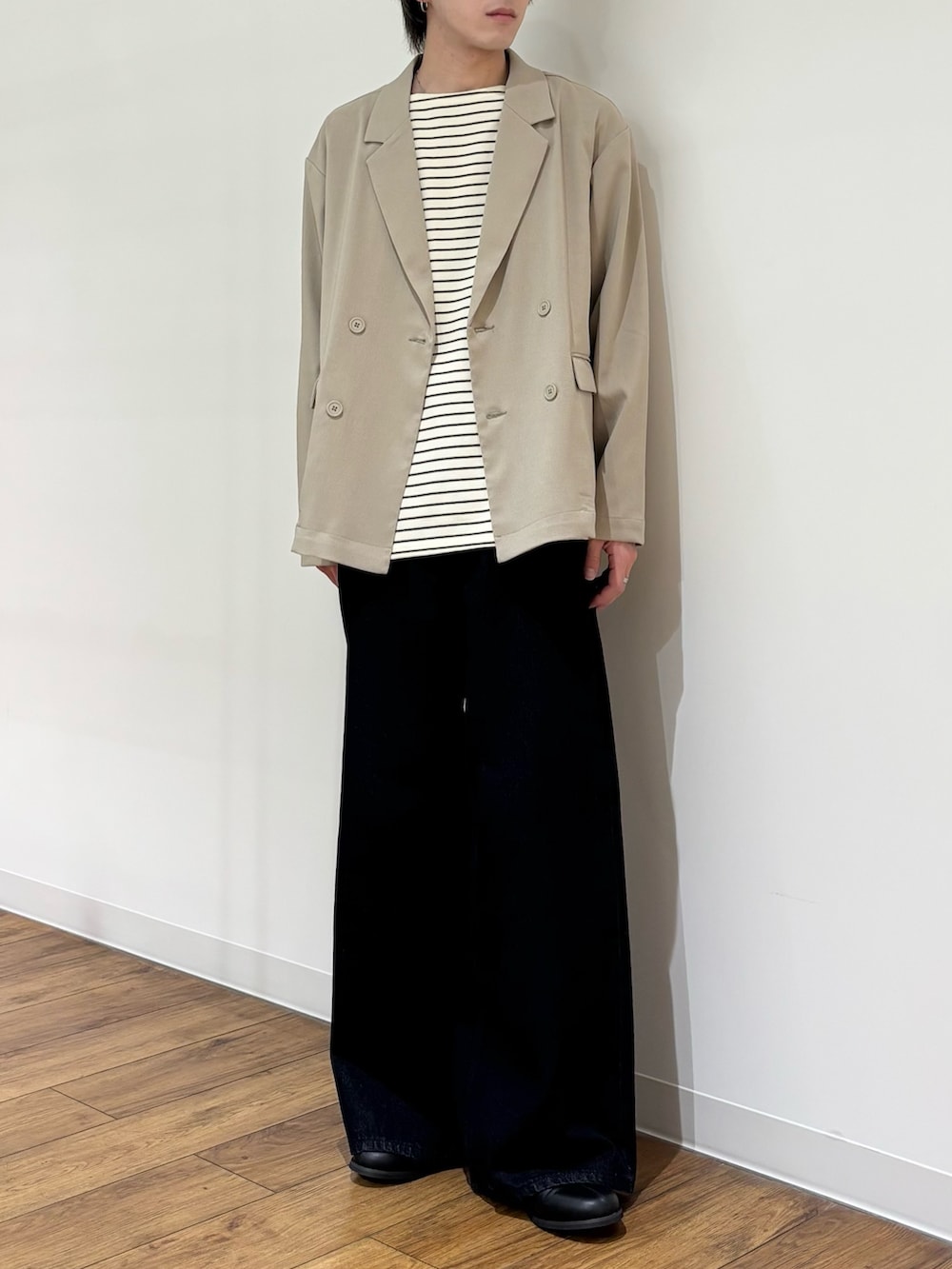 ベージュ系のテーラードジャケット、ホワイト系のTシャツ/カットソー、ブルー系のデニムパンツを着用したメンズの春コーディネートの3枚目の写真