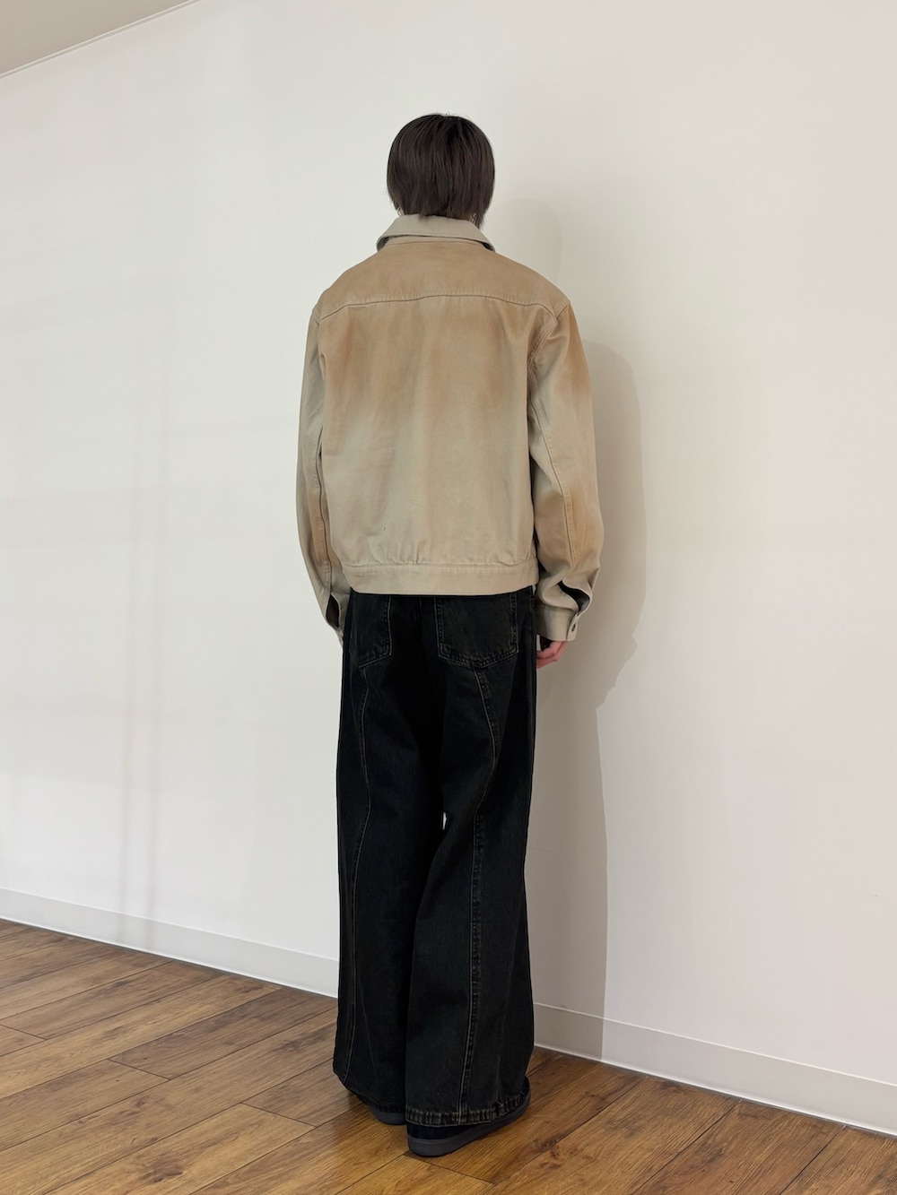 グリーン系のデニムジャケット、ブラック系のニット/セーター、ブラック系のデニムパンツを着用したメンズの冬コーディネートの4枚目の写真