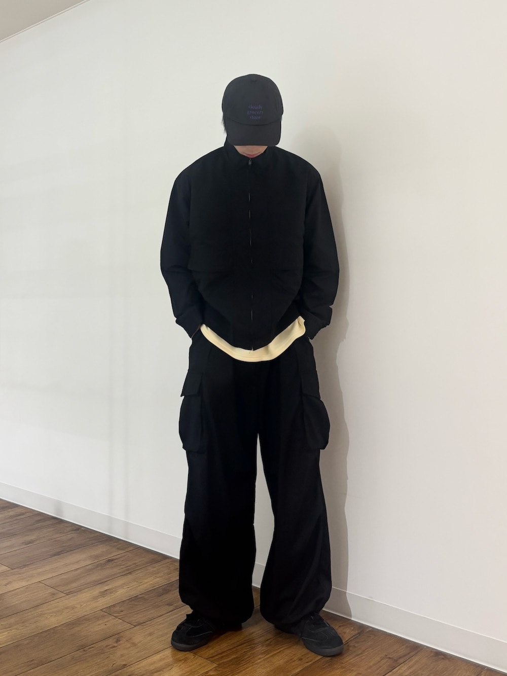 ブラック系のブルゾン、イエロー系のTシャツ/カットソー、ブラック系のカーゴパンツを着用したメンズの春コーディネートの6枚目の写真