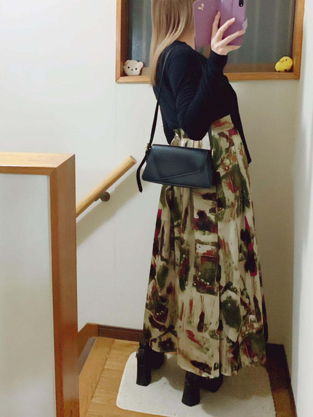 ブラック系のパンプス、グリーン系のスカート、ブラック系のショルダーバッグを着用したレディースの冬コーディネートの5枚目の写真