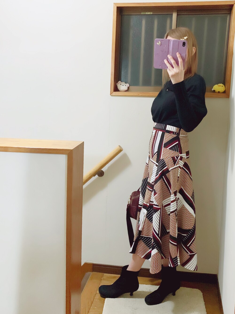 ブラック系のTシャツ/カットソー、ブラウン系のスカート、レッド系のショルダーバッグを着用したレディースの秋コーディネートの3枚目の写真