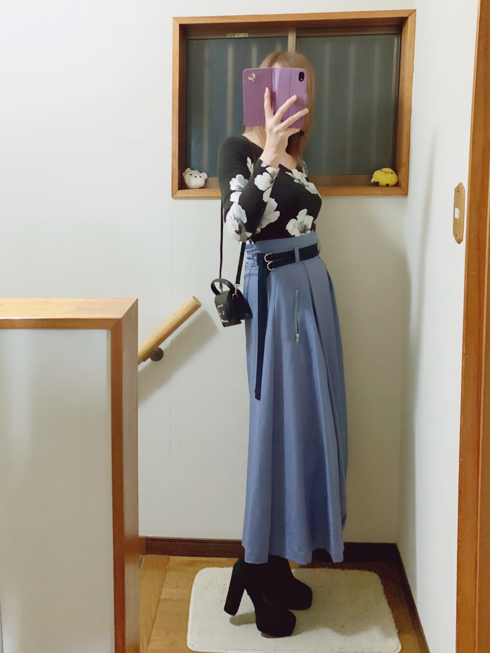 ブラック系のブーツ、ブルー系のスカート、ブラック系のショルダーバッグを着用したレディースの秋コーディネートの3枚目の写真