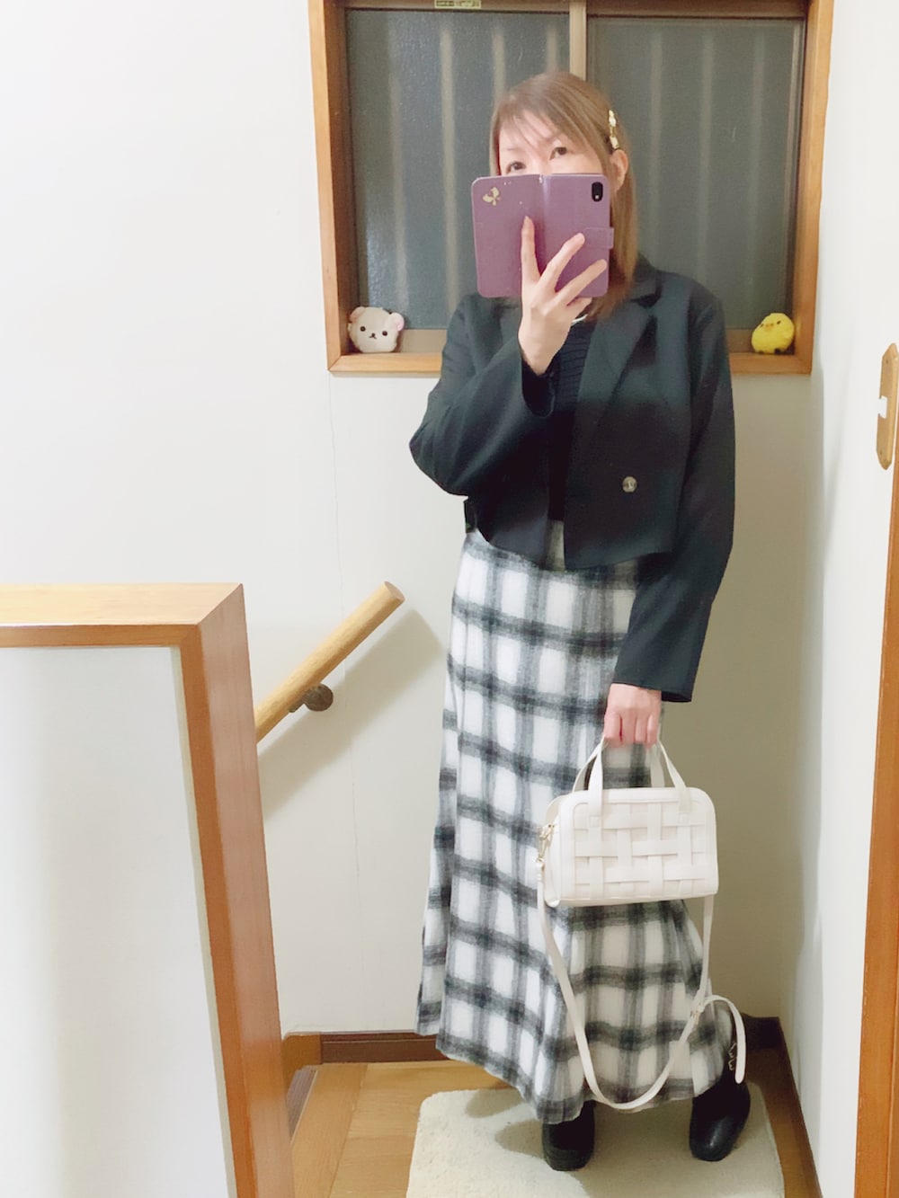 ブラック系のテーラードジャケット、ブラック系のパンプス、ホワイト系のスカートを着用したレディースの冬コーディネートの3枚目の写真