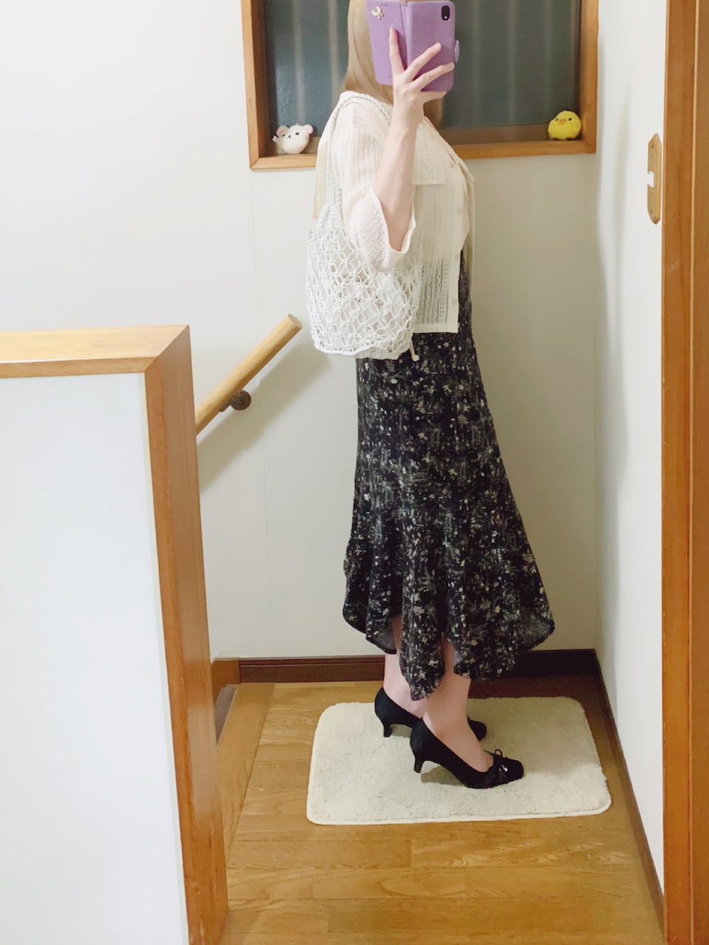 ブラック系のパンプス、ブラック系のスカート、ホワイト系のハンドバッグを着用したレディースの夏コーディネートの2枚目の写真