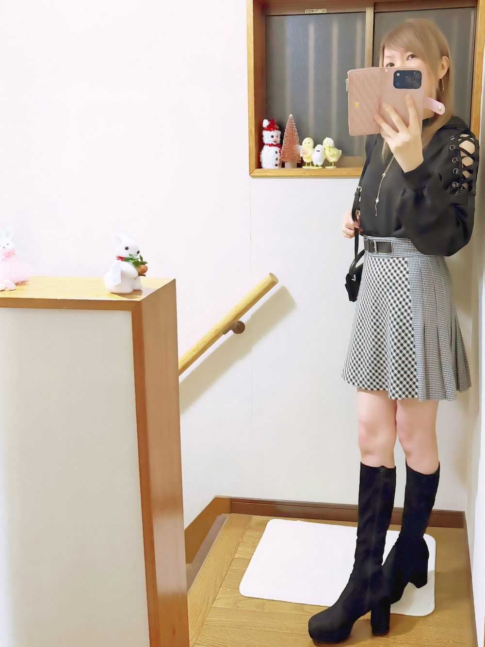 ブラック系のブーツ、ブラック系のパーカー、ブラック系のスカートを着用したレディースの秋コーディネートの4枚目の写真