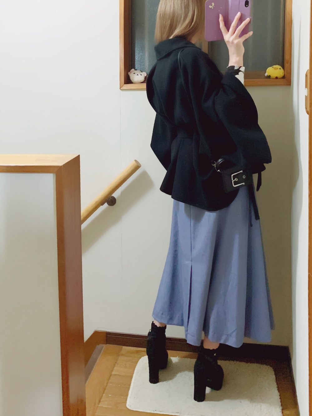 ブラック系のブーツ、ブルー系のスカート、ブラック系のショルダーバッグを着用したレディースの秋コーディネートの4枚目の写真