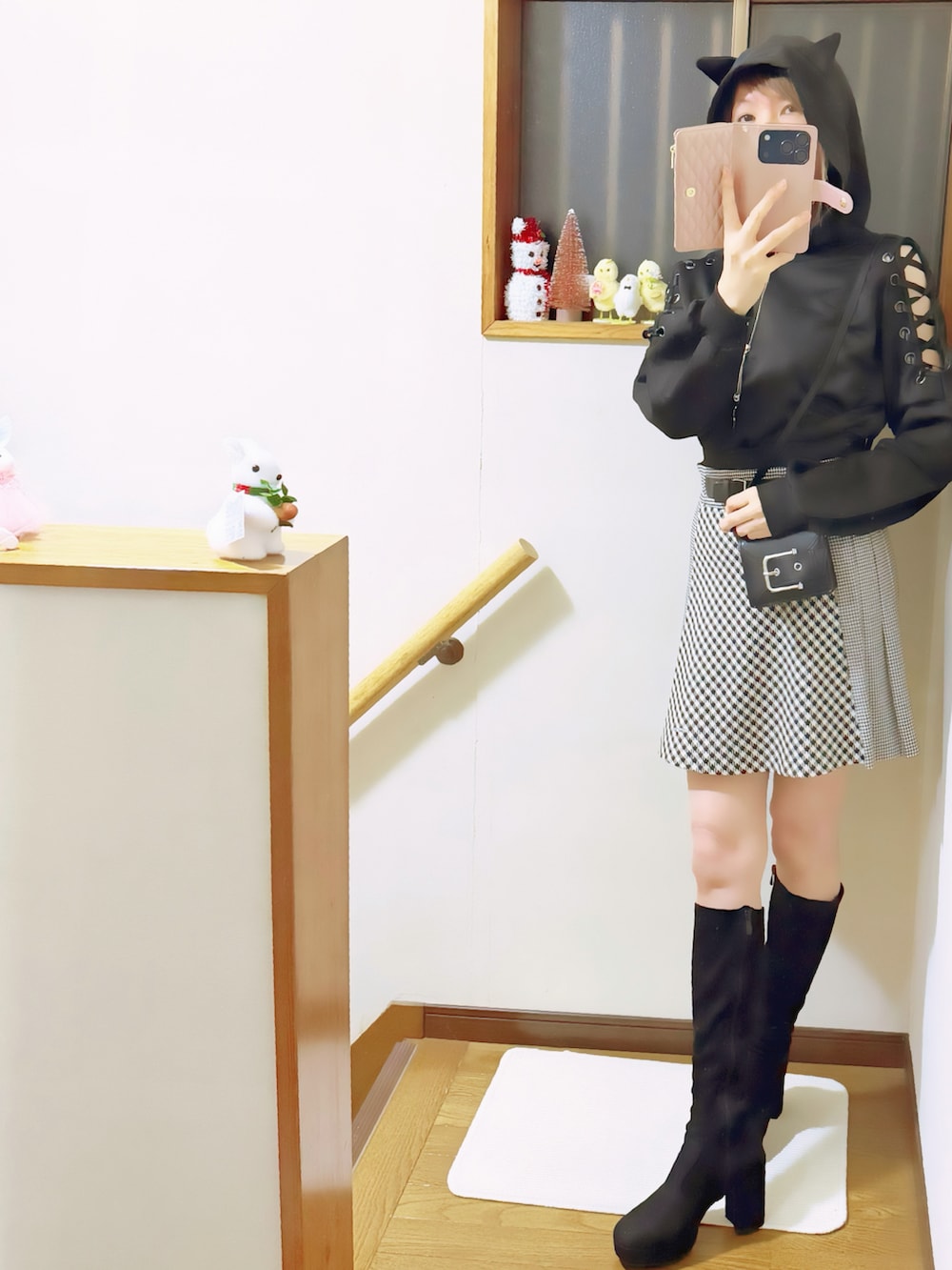 ブラック系のブーツ、ブラック系のパーカー、ブラック系のスカートを着用したレディースの秋コーディネートの2枚目の写真