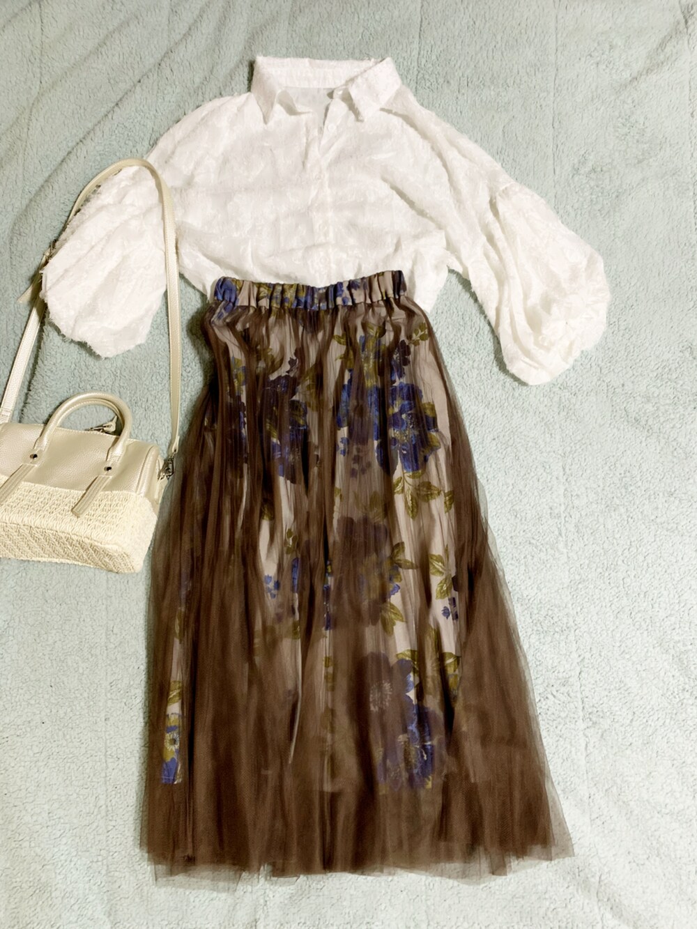 ホワイト系のサンダル、ブラウン系のスカート、ホワイト系のかごバッグを着用したレディースの夏コーディネートの4枚目の写真