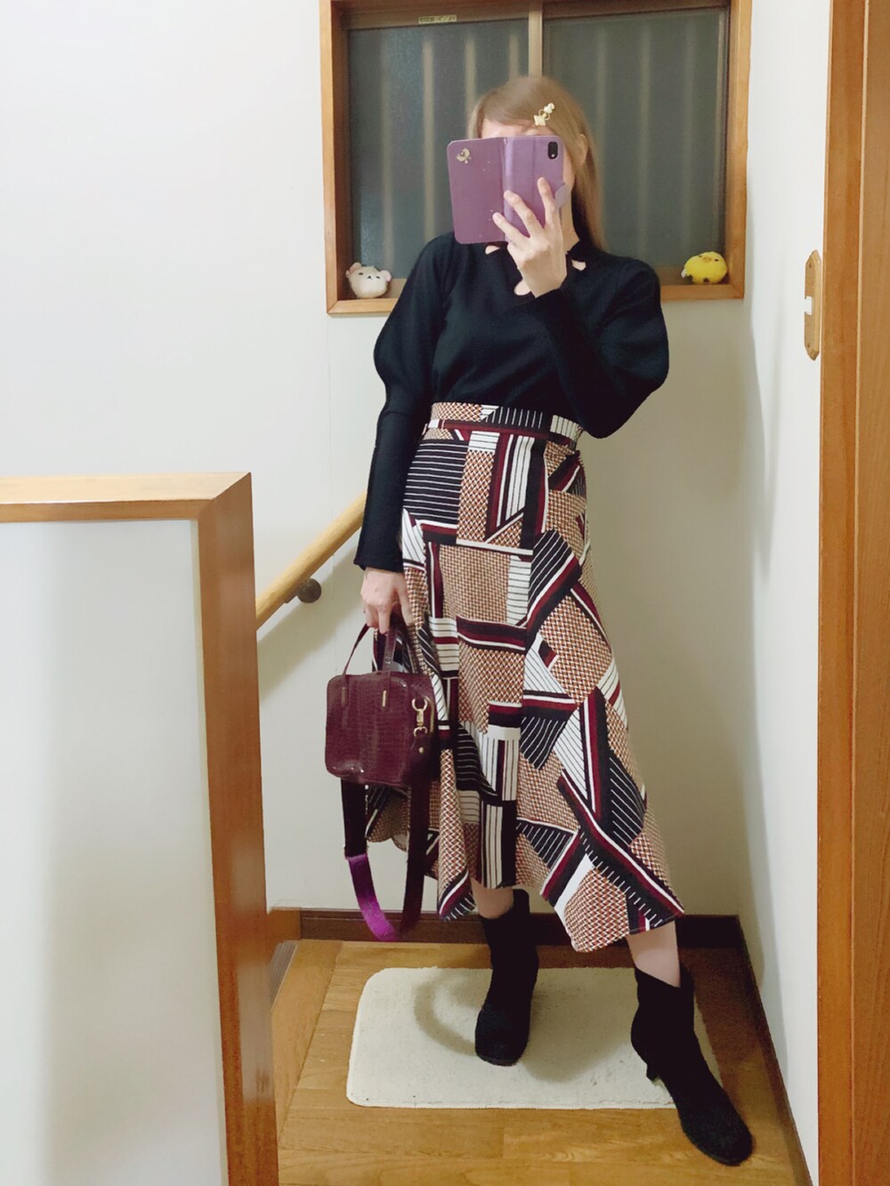 ブラック系のTシャツ/カットソー、ブラウン系のスカート、レッド系のショルダーバッグを着用したレディースの秋コーディネートの2枚目の写真