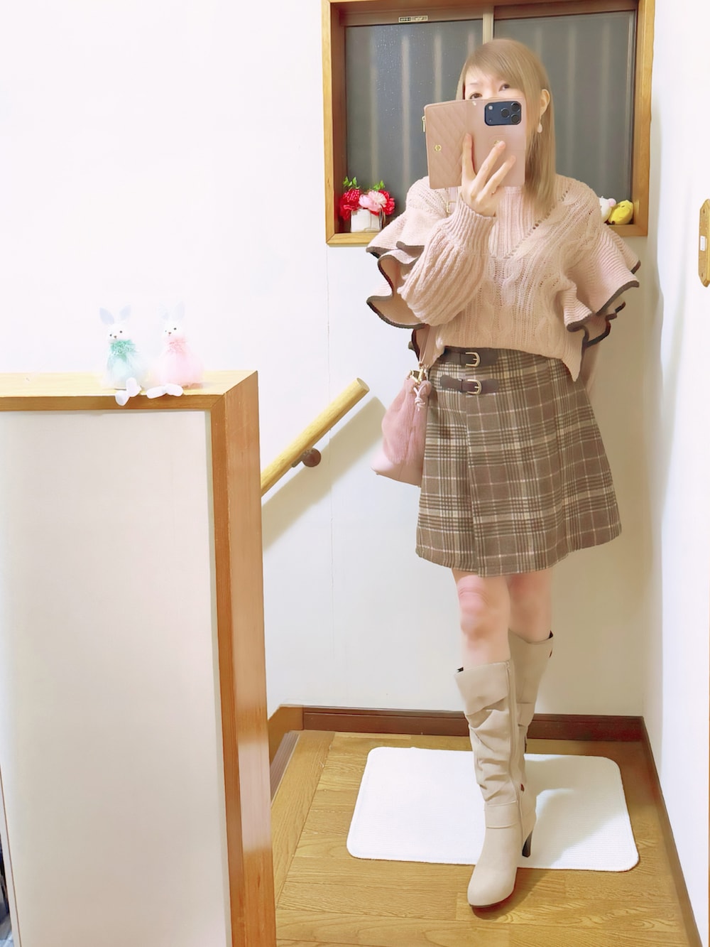 ブラウン系のブルゾン、ピンク系のハンドバッグ、ピンク系のニット/セーターを着用したレディースの冬コーディネートの4枚目の写真