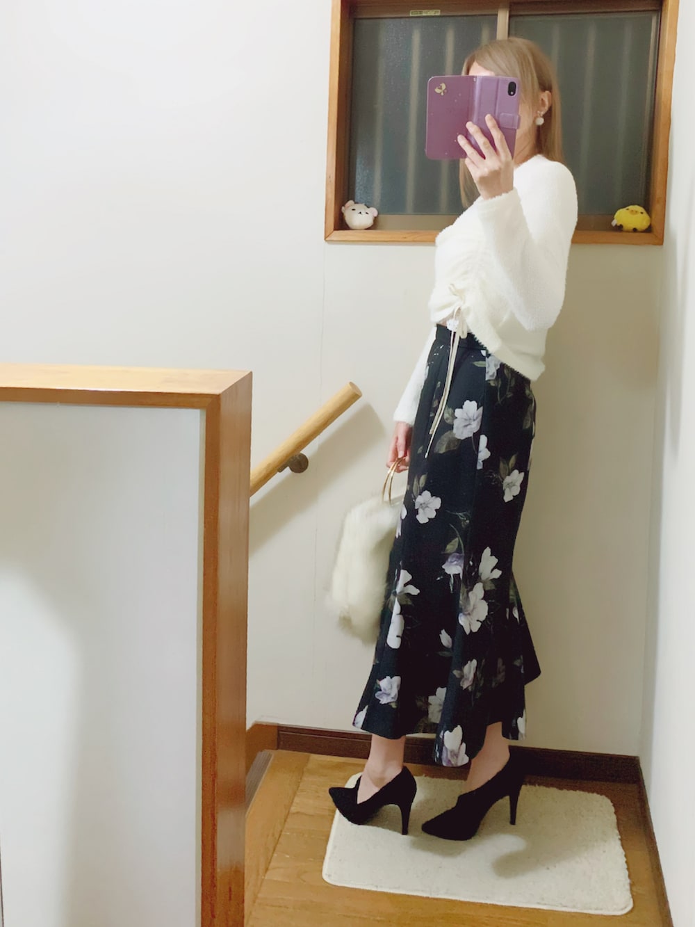 ブラック系のパンプス、ブラック系のスカート、ホワイト系のハンドバッグを着用したレディースの秋コーディネートの3枚目の写真