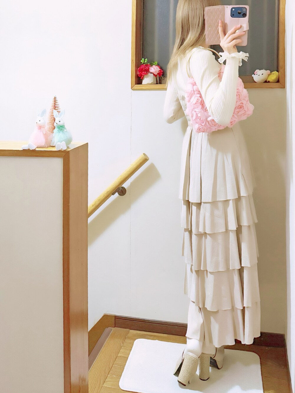 ベージュ系のワンピース、ベージュ系のサンダル、ホワイト系のニット/セーターを着用したレディースの冬コーディネートの4枚目の写真