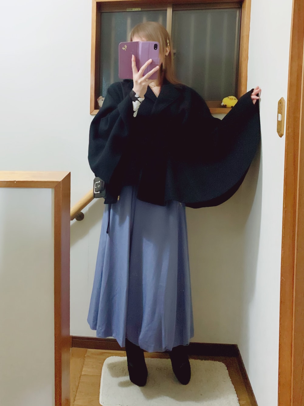 ブラック系のブーツ、ブルー系のスカート、ブラック系のショルダーバッグを着用したレディースの秋コーディネートの2枚目の写真