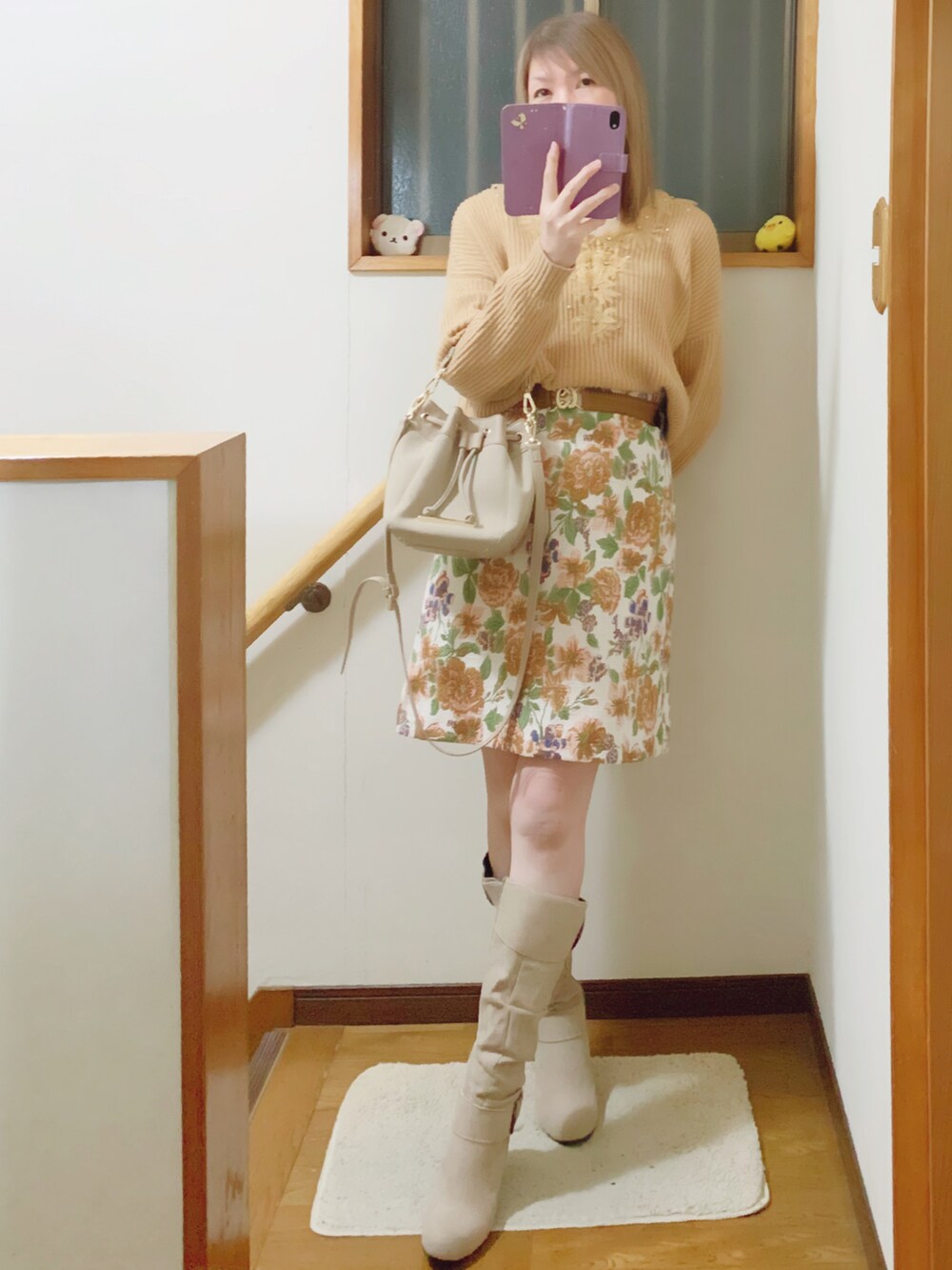 ベージュ系のニット/セーター、ベージュ系のショルダーバッグ、ホワイト系のジャケット/アウターを着用したレディースの冬コーディネートの2枚目の写真
