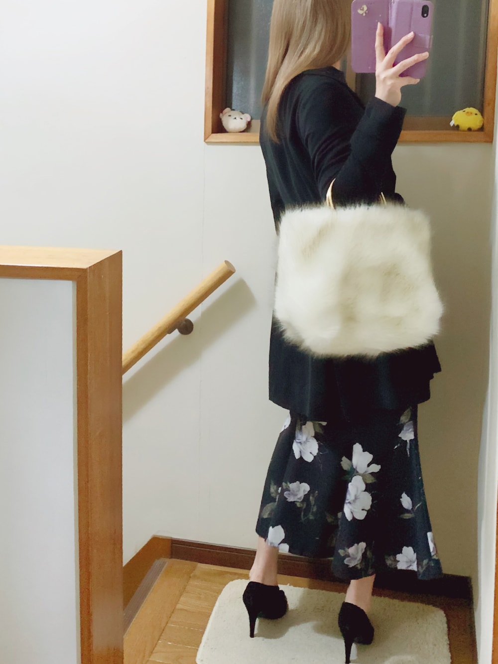 ブラック系のパンプス、ブラック系のスカート、ホワイト系のハンドバッグを着用したレディースの秋コーディネートの4枚目の写真