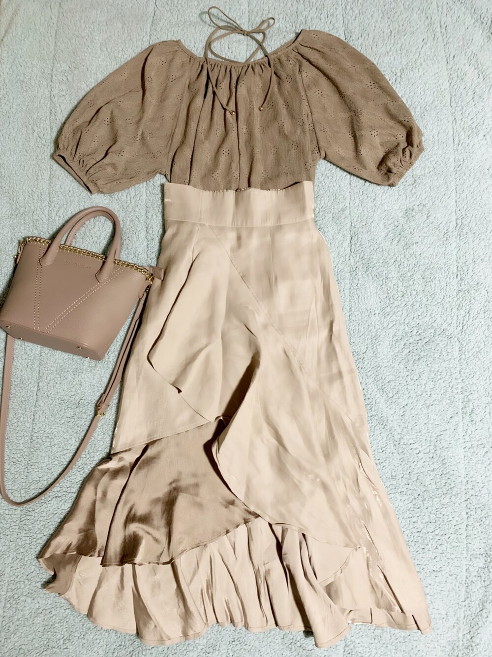 グレー系のサンダル、ベージュ系のスカート、ベージュ系のショルダーバッグを着用したレディースの夏コーディネートの3枚目の写真