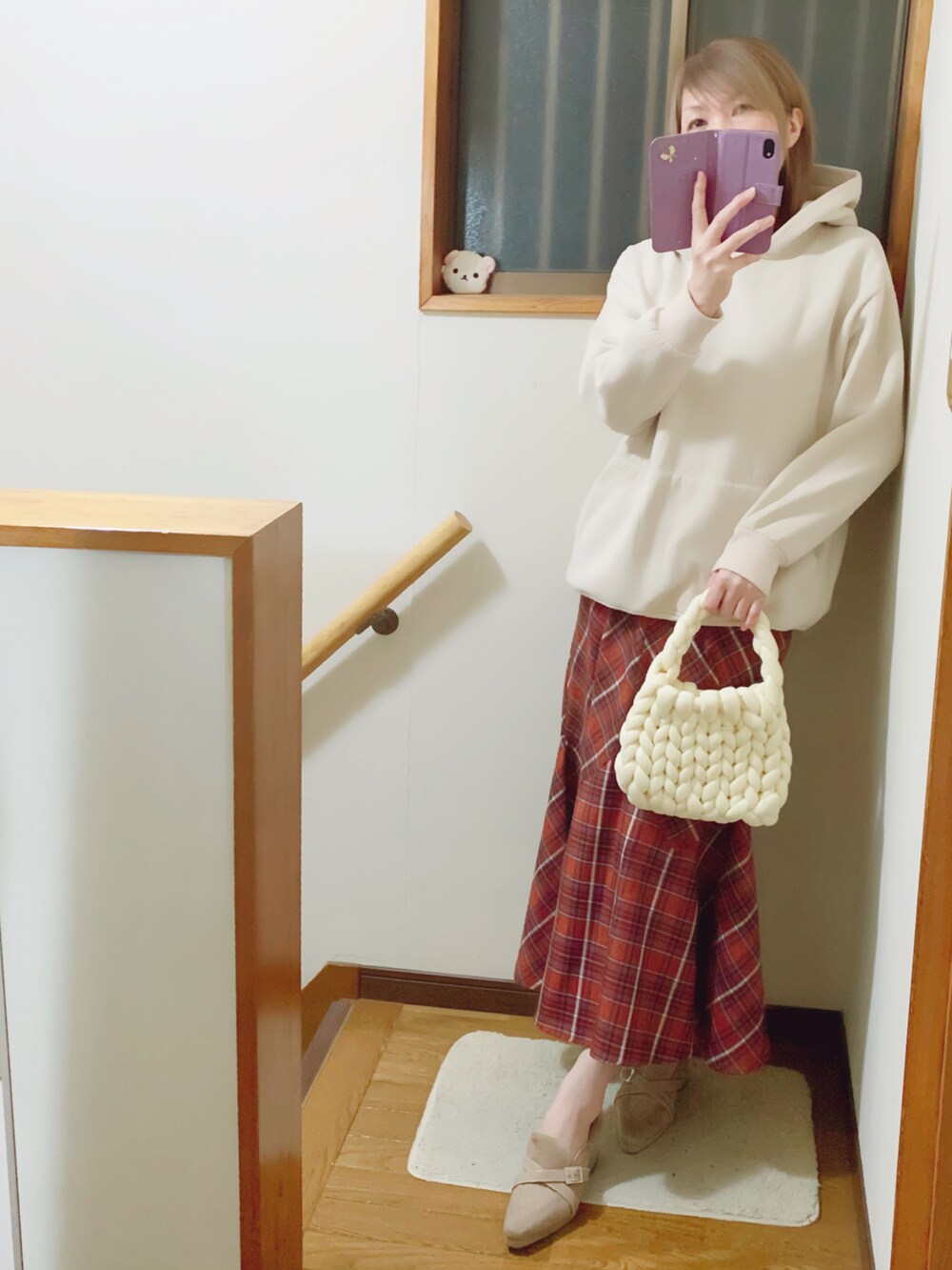 ホワイト系のパーカー、ブラウン系のスカート、ホワイト系のトートバッグを着用したレディースの冬コーディネートの3枚目の写真