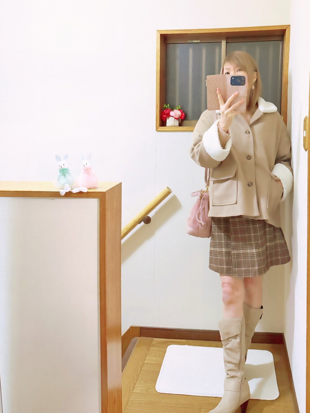 ブラウン系のブルゾン、ピンク系のハンドバッグ、ピンク系のニット/セーターを着用したレディースの冬コーディネートの2枚目の写真