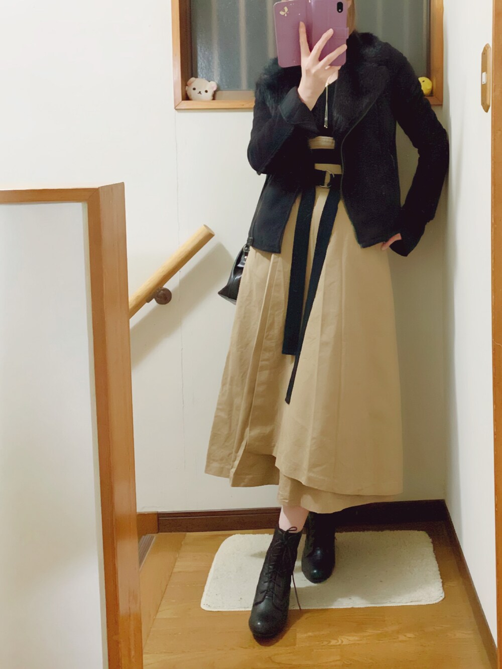 ブラック系のブーツ、ベージュ系のスカート、ブラック系のショルダーバッグを着用したレディースの冬コーディネートの4枚目の写真